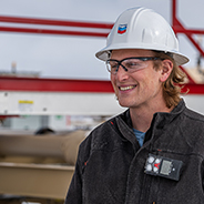 a smiling Chevron employee wearing a hard hat